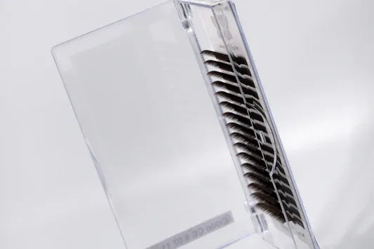 Black false eyelashes on strips in an open clear plastic case.